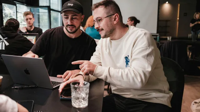 Two colleagues reviewing a course together on a laptop